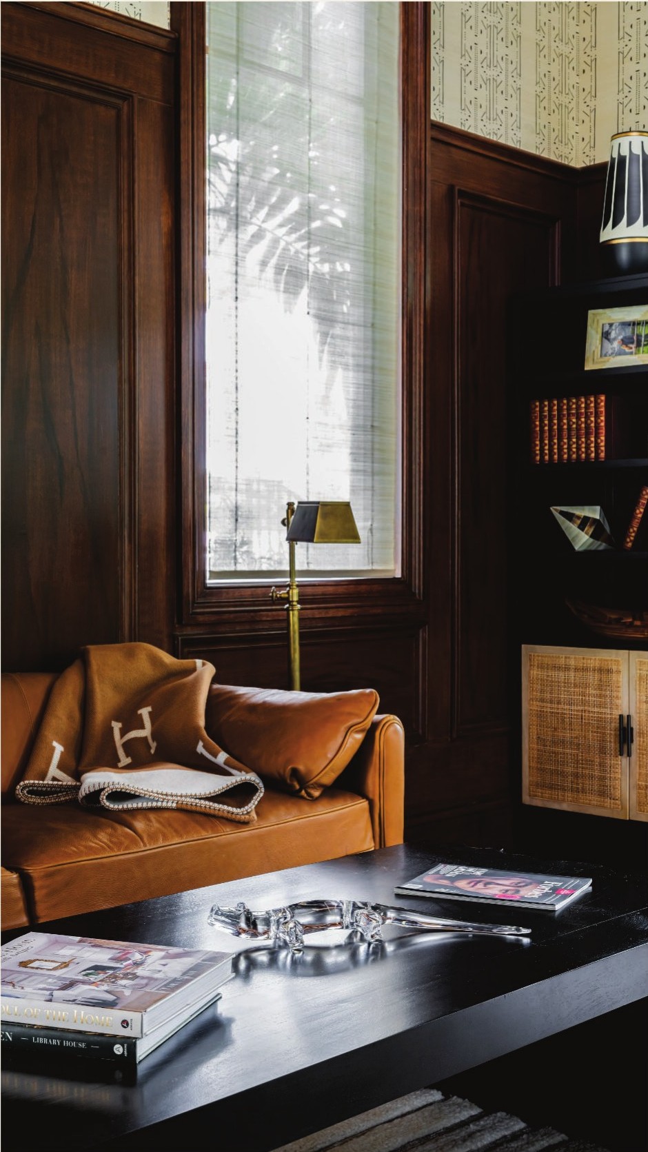 Paneled office with a tan leather sofa and Hermès throw.